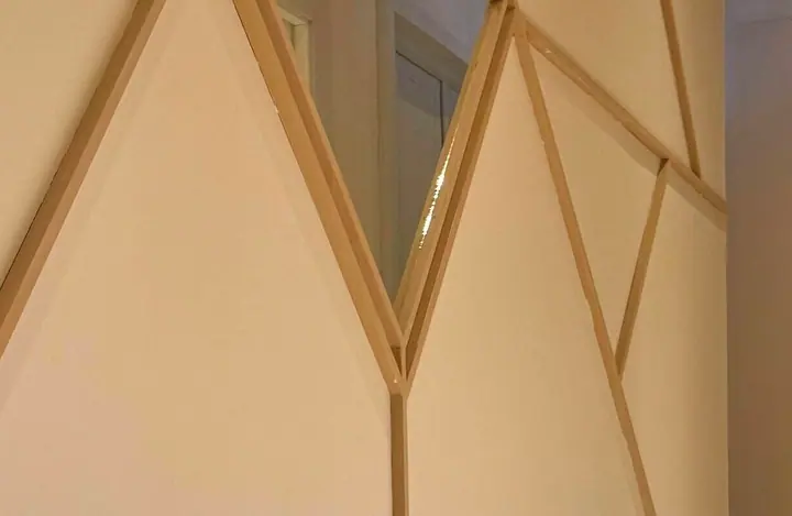 Brass chevron battens catching the skirting light.