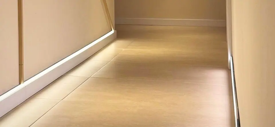 The concealed LED running along the skirting, throwing light up the cream wall.